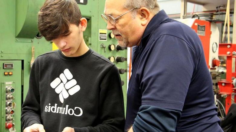 Penn State DuBois die setting instructor George Schneider, left, works with Saint Marys Area High School student Dakota Larkham to measure one of the parts produced during the high school die setter training program.